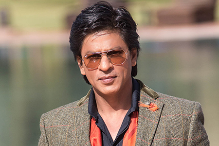Actor Shah Rukh Khan portrait in brown/orange suit with tinted glasses