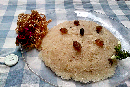 Suji dish on clear plate topped with raisins and decorative garnish