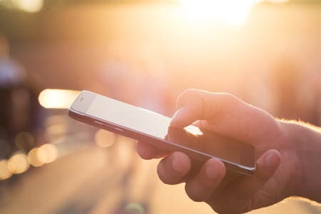 close up of man's hand using smartphone