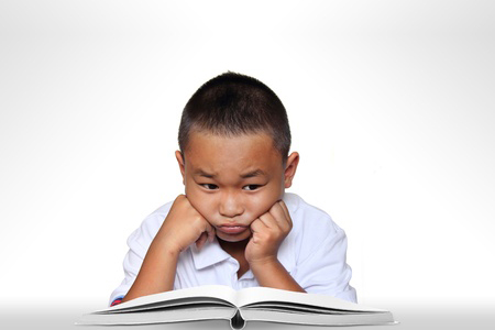 young boy with open book looking upset