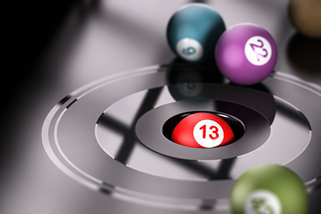 Gambling concept, chance and number thirteen One ball with the number 13 inside a hole with other ba