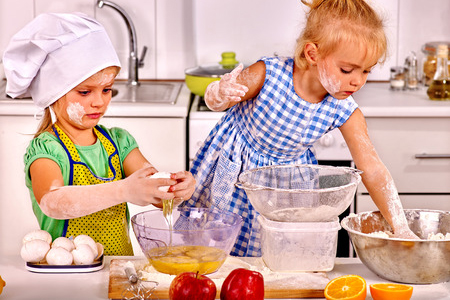 Two messy kids learn preparing breakfast at home kitchen