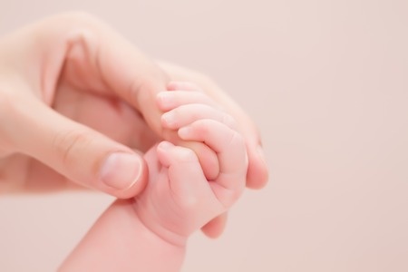 Concept of love and family. hands of mother and baby closeup