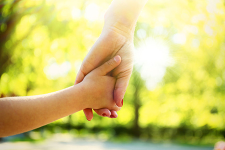 Hands of mother and daughter holding each other