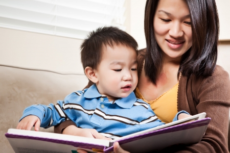 Mother reading book to child on lap
