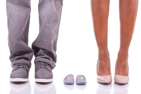 cropped image of parents feet with baby booties