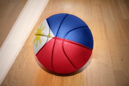 basketball ball with the national flag of philippines lying on the floor near the white line