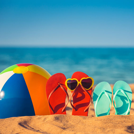 Seasonal Summer - beachball and flip flops at the beach