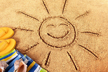 picture of smiling sun drawn in sand