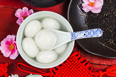 Chinese style glutinous rice balls served in a bowl with Chinese New Year decoration