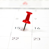 Embroidered red pins on a calendar on the 15th with selective focus