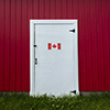 Red building exterior with white door - canada flag printed on door
