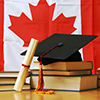 stalk of books, diploma and graduation cap in front of canada flag