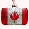 Tourist hand holding vintage leather travel bag with flag of Canada