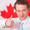 man giving thumbs up in front of canada flag
