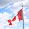 Canada flag waving in bright sky