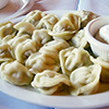 Russian Pelmeni on plate with white dipping sauce