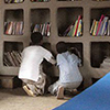View inside Awra Amba community library, Ethiopia. People searching for book on shelf