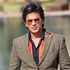 Actor Shah Rukh Khan portrait in brown/orange suit with tinted glasses