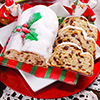 christmas stollen cake partly sliced with dried fruits and marzipan on festive table