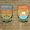 Coat of arms for Canadian provinces Quebec and New Brunswick on brick wall