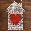 Handmade home symbol with heart shape on wooden background with copy space