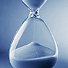 Closeup hourglass clock on light blue background