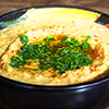 Hummus with garnish in black bowl