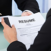 over-the-shoulder view of woman holding resume