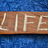 LIFE written in chalk on wood block