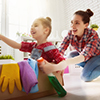 Mother and daughter do the cleaning in the house. A young woman and a little child girl having fun a