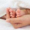 Baby's feet cradled in mother's palm