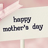 Cupcake with pink frosting and Happy Mothers Day message with pink bow. Blurred background