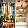 Clothes hung neatly in organized closet at home (wardrobe)