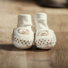 close up of parents feet with baby shoes in the centre