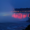 Niagara falls lit up with coloured lights at night time