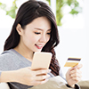 Young woman holding mobile phone and credit card 