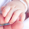 close up of newborn's hand gripping parent's finger