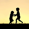Silhouette of siblings playing