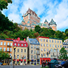 Chateau Frontenac in the day with colorful buildings on street in Quebec City