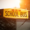Front closeup view of yellow school bus windshield sign at sunset