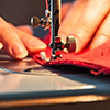close up of woman's hands sewing on machine