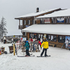 Group of people at snow resort dressing for winter sports