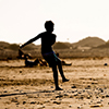Silhouette of boy on the beach, playing football