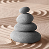 stacked pebbles and pattern in sand - tranquility concept
