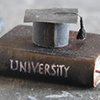 University Degree Concept. Vintage book with inscription and graduation cap