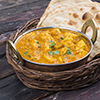 steel dish with veggie korma - served in basket tray with naan