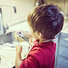 young boy washing dishes