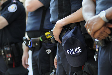 Four Toronto Police officers standing side by side wearing gear. Cropped image without faces visible