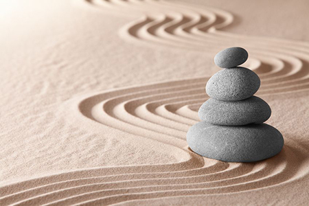 stacked pebbles and pattern in sand - tranquility concept